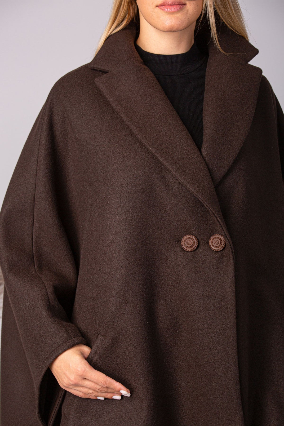Close look of elegant off-white cape with lapel and oversized fit